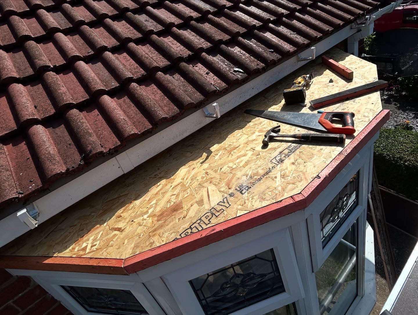 Bay window flat roof preparation with OSB board and tools