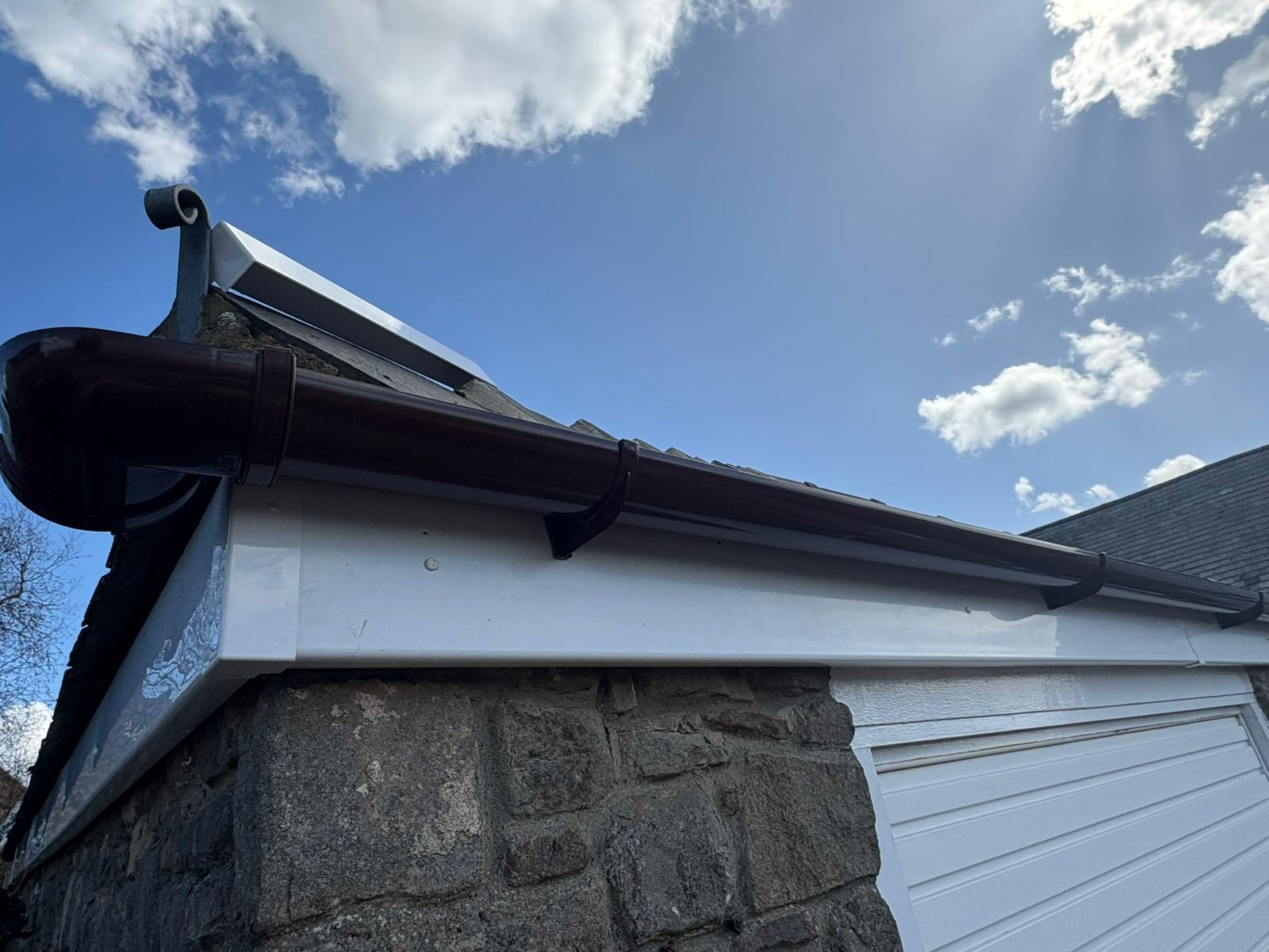 New uPVC gutter and downpipe installation on residential property roofline