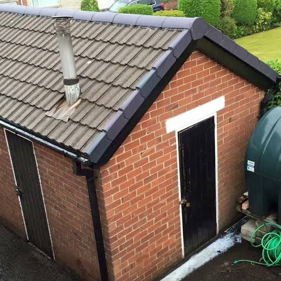Completed roof with new tiles and dry verge on outbuilding