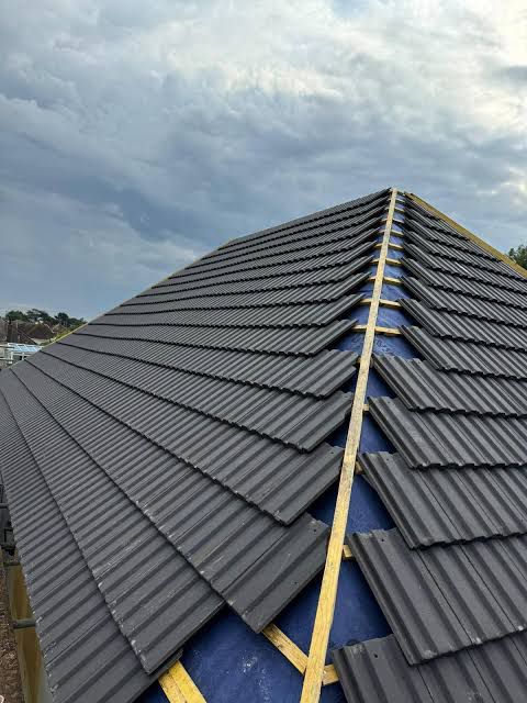 New corrugated roof tiles being installed on steep pitch