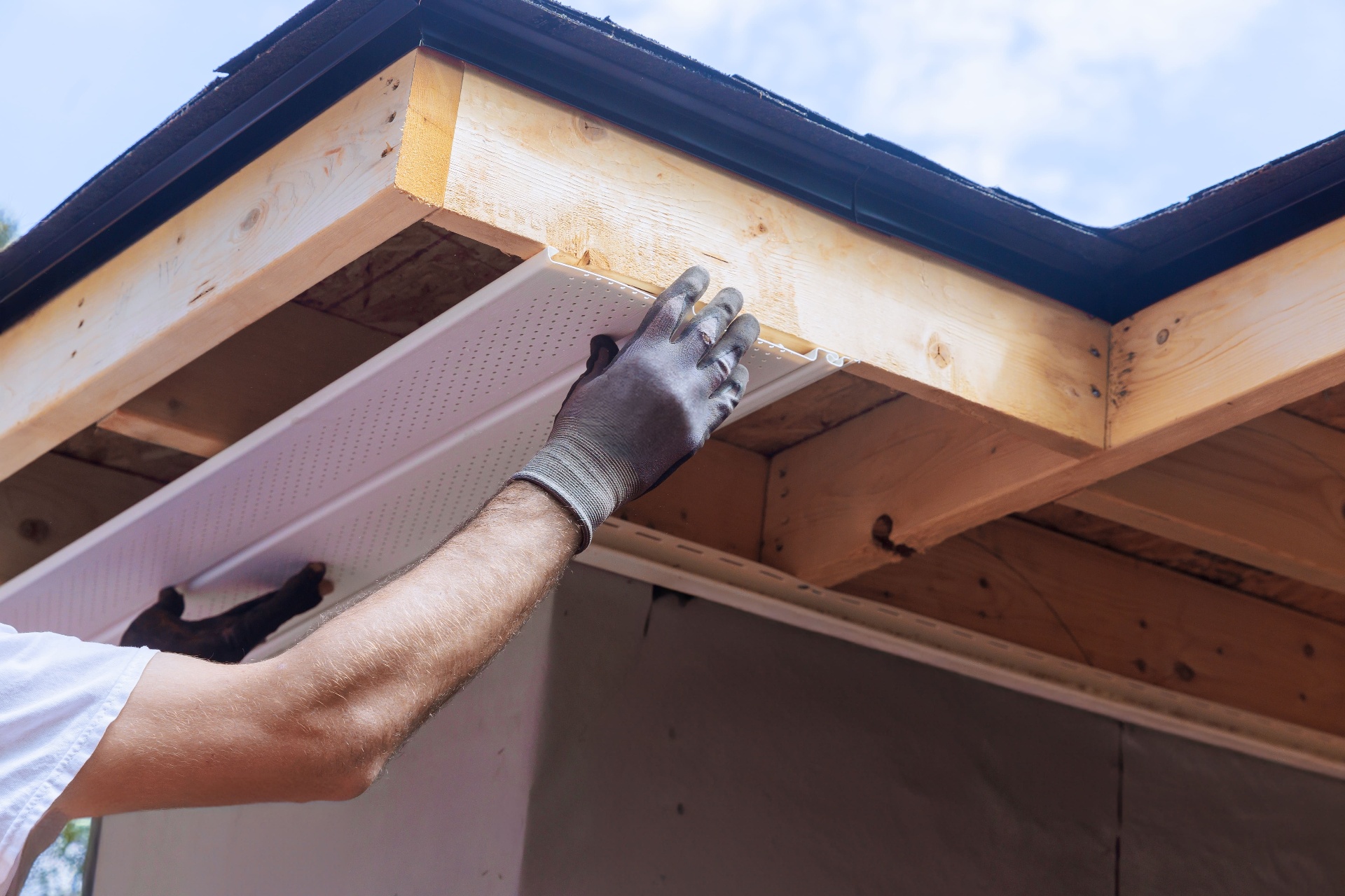 uPVC soffit panel being fitted under roof overhang for ventilation