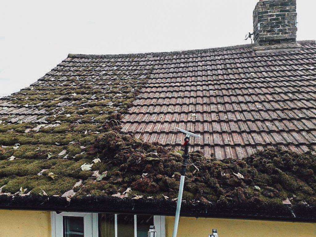 Professional roof cleaner soft-washing moss off a tiled roof in County Durham
