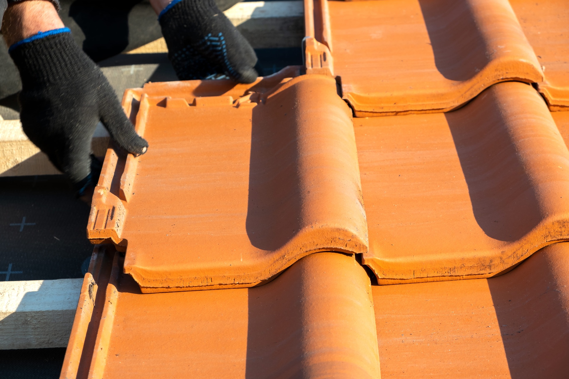 New concrete roof tiles being fitted during a full roof replacement in County Durham